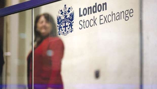 A visitor passes a sign inside the London Stock Exchange. The FTSE 100 closed down 0.5% at 7,372.92 points yesterday.