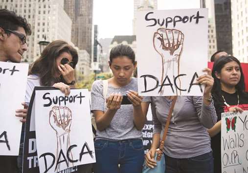 (From left) Marlon Ruales, Dayana Arrue, Sofia Ruales, and Erica Ruales, all in their early 20s and u201cDreamersu201d originally from Ecuador, watch Attorney General Jeff Sessionsu2019 remarks on ending the Deferred Action for Childhood Arrivals programme on Sofiau2019s smartphone before a protest in Grand Army Plaza in Manhattan yesterday.