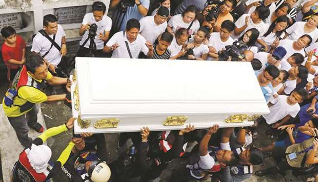 Mourners carry the coffin of 19-year-old Carl Angelo Arnaiz, accused of robbery and shot dead by police, during the funeral in Pateros, Metro Manila yesterday.