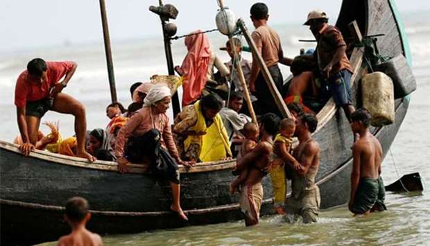 Rohingya refugees get off the boat as they arrive in Bangladesh through the Bay of Bengal.