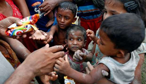 Rohingya refugees stretch their hands for food after crossing the Bangladesh-Myanmar border, in Teknaf, Bangladesh. AFP