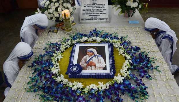 Roman Catholic nuns of the Missionaries of Charity order pray at the tomb of Mother Teresa