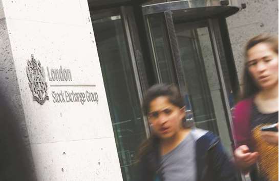 Pedestrians walk past the London Stock Exchange. The FTSE 100 slid 0.3% to 7,354.13 points yesterday.
