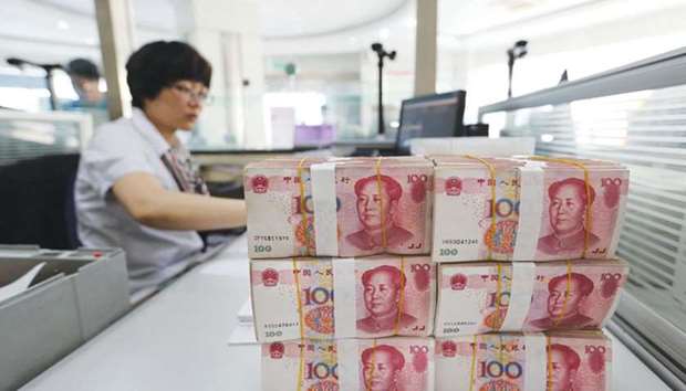 Yuan banknotes are placed on a staffu2019s table in a bank in Lianyungang, China. The yuan has surged 3.9% to be the best performer in Asia this quarter, while momentum indicators are near the highest since 2005.