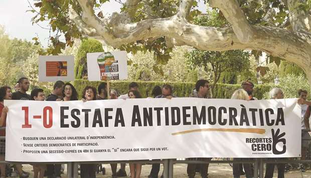 A group of people hold a banner yesterday reading u2018October 1, Antidemocratic scamu2019 to protest against the referendum on independence in Catalonia, in front of the Catalan regional Parliament in Barcelona.