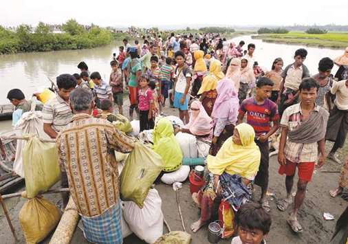 Rohingya refugees are seen waiting for a boat to cross the border through the Naf river in Maungdaw, Myanmar.