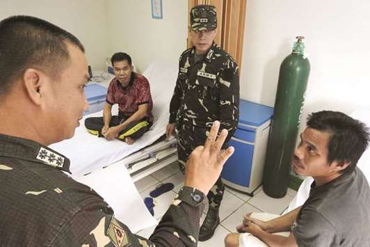A military officer talks to former Indonesian hostages at a military hospital in Jolo.