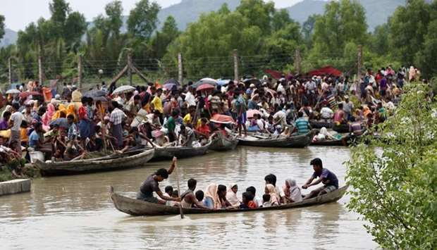 A boat carrying Rohingya refugees is seen leaving Myanmar through Naf river while thousands other waiting in Maungdaw, Myanmar.