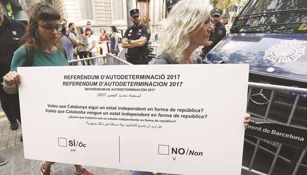 Maria Rovira (left) and Maria Jose Lecha, members of the Catalan pro-independence anti-capitalist party Candidatura du2019Unitat Popular (CUP, Popular Unity Candidacy), deliver a mock referendum ballot at the regional government office in Barcelona.