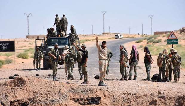 Syrian government forces gesture as they arrive at Deir al-zor
