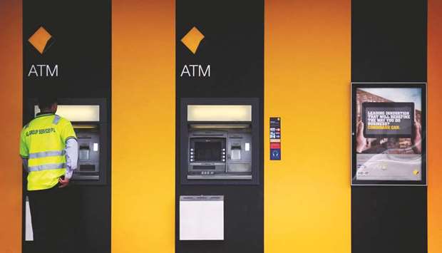 A man uses a Commonwealth Bank ATM located outside a branch in Sydney. Australiau2019s banking regulator spelled out plans yesterday for a major investigation into back-to-back scandals at CBA, warning that public trust in the financial sector was at rock bottom.