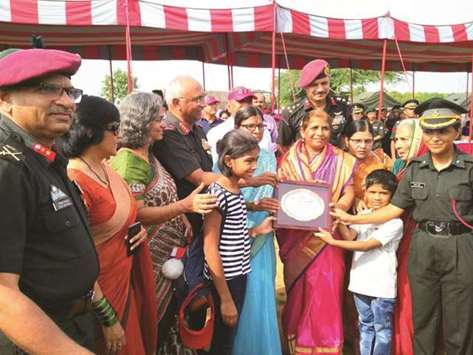 Lt Swati Santosh Mahadik poses with a memento of 41 Rashtriya Rifles as her children, parents and in-laws look on.