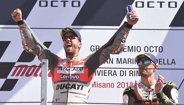 Ducatiu2019s Italian rider Andrea Dovizioso (left) celebrates after winning the San Marino MotoGP as third placed Honda Castrolu2019s British rider Cal Crutchlow applauds on the podium in Misano, Italy, yesterday. (AFP)