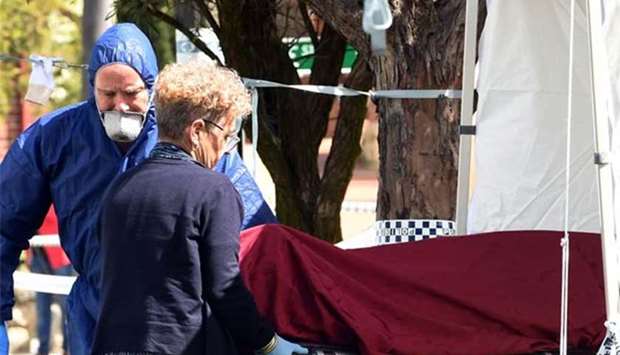 Forensic police remove bodies from the crime scene in Perth on Monday.