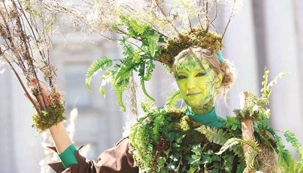 A woman dressed as a tree, with the group The Forgotten Solution, poses for a picture at Civic Center Plaza after marching at the u2018Rise For Climateu2019 global action in downtown San Francisco on Saturday.