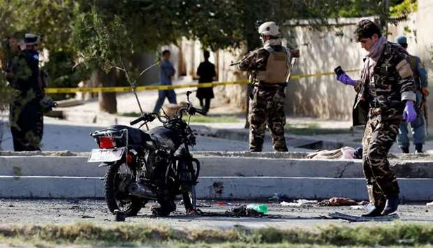 Afghan security forces inspect the site of an attack in Kabul