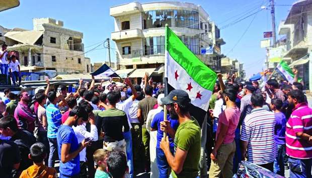 Syrians chant slogans and wave flags of the opposition as they protest against the regime and its ally Russia, in Binnish in Idlib province yesterday.