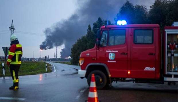 Firefighters stand next to the site of a refinery of Bayernoil company where an explosion took place in Vohburg near the Bavarian town of Ingolstadt on Saturday.