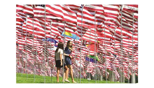 Young girls visit the u2018Waves of Flagsu2019 display at Pepperdine University in Malibu, California where the annual display of 2,997 flags commemorates victims of the September 11, 2001 terrorist attacks.