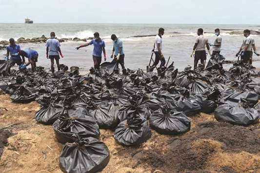 Sri Lankan soldiers work to remove oil from a pipeline leak from the beach at Uswetakeiyawa, a coastal town north of Colombo, yesterday. The spill that started on September 8 was caused by a pipeline leak, officials said, and the oil flow was confined to a approximately 5km stretch of coastline before the leak was halted.