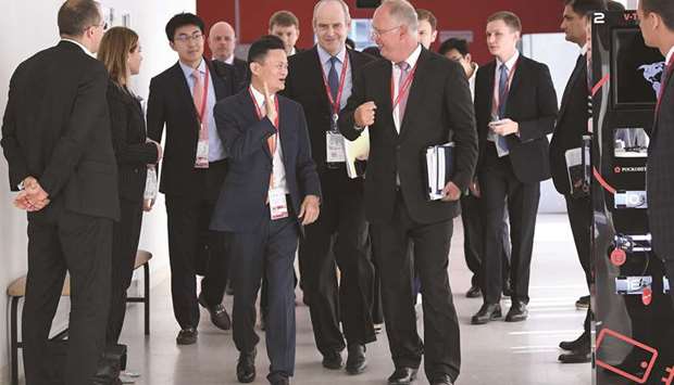 Alibaba Group co-founder and executive chairman Jack Ma speaks to Alibabau2019s president Michael Evans and Russian Direct Investment Fund CEO Kirill Dmitriev during the Eastern Economic Forum in Vladivostok, Russia yesterday. Both firms said they would launch a joint e-commerce venture in Russia and former Soviet countries.