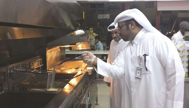 An inspectors checking on the condition of a fryer.