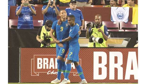 Brazilu2019s Richarlison (left) celebrates with teammate Douglas Costa after scoring against El Salvador in a friendly match. (AFP)