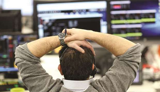 A broker looks at financial information on computer screens on the IG Index trading floor in London (file). The FTSE 100 rose 0.6% to close at 7,313.36 points yesterday.