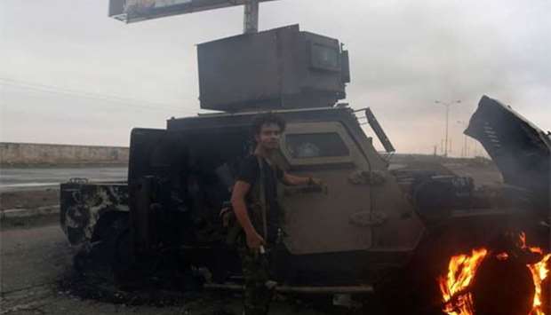 A Houthi rebel inspects a burnt armoured vehicle during clashes near the eastern entrance of the Yemeni city of Hodeida.