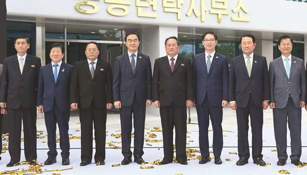 South Korean unification minister Cho Myoung-gyon and his North Korean counterpart Ri Son-gwon pose for a photo session during an opening ceremony of a joint liaison office in Kaesong, North Korea, yesterday.