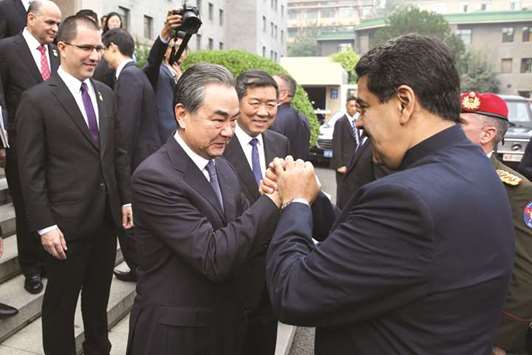 Venezuelau2019s President Nicolas Maduro shakes hands with Chinau2019s Foreign Minister Wang Yi as they meet in Beijing, China, yesterday.