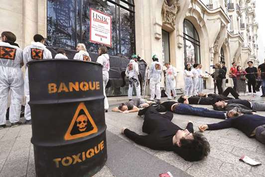 Activists from the Association for the Taxation of Financial Transactions and Citizenu2019s Action (Attac) stage a protest yesterday in front of the HSBC bank against its investment in fossil fuel between 2015 and 2017, at the Champs Elysee in Paris.