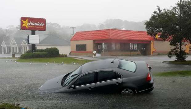 A car washed away by flood waters remains partially submerged as torrential rains continue after Hurricane Florence struck in Southport, North Carolina, US