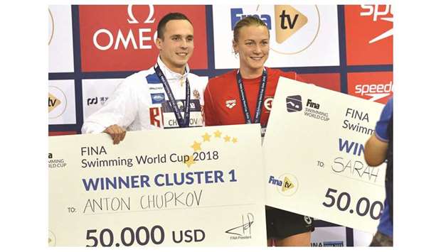 Overall winners Anton Chupko and Sarah Sjostrom pose with their cheques. PICTURE: Noushad Thekkayil