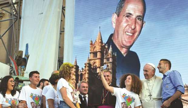 Pope Francis poses for selfies with youth on Piazza Politeama in Palermo, below a portrait of slain Sicilian priest Pino Puglisi, during his one-day visit on the occasion of the 25th anniversary of Puglisiu2019s killing by the mafia.