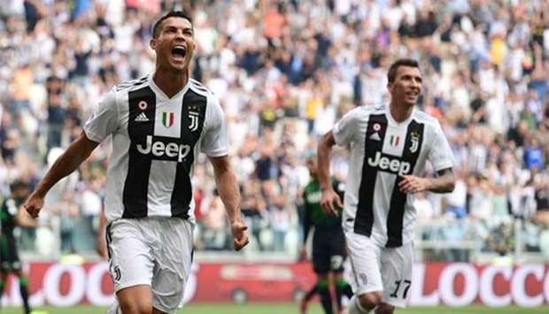 Cristiano Ronaldo celebrates with Mario Mandzukic after he scored his first goal for Juventus in Turin on Sunday.