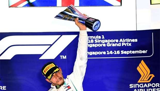 Mercedes' British driver Lewis Hamilton holds up the trophy after winning the Singapore Formula One Grand Prix at the Marina Bay Street Circuit in Singapore on Sunday.