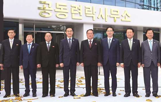 South Korean unification minister Cho Myoung-gyon (L from C) and his North Korean counterpart Ri Son-gwon (R from C) pose for a photo session during an opening ceremony of a joint liaison office in Kaesong, North Korea, on Friday.