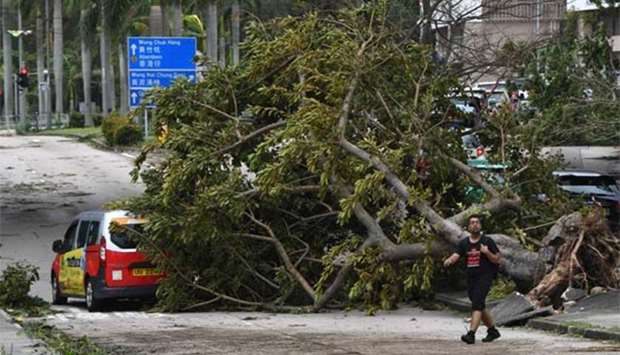 A damaged taxi sits under a fallen tree in the aftermath of Typhoon Mangkhut in Hong Kong on Monday.