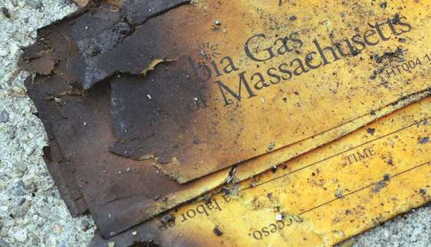 A burnt Columbia Gas of Massachusetts envelope sits on the sidewalk outside a home burned during a series of gas explosions in Lawrence, Massachusetts, on Thursday.