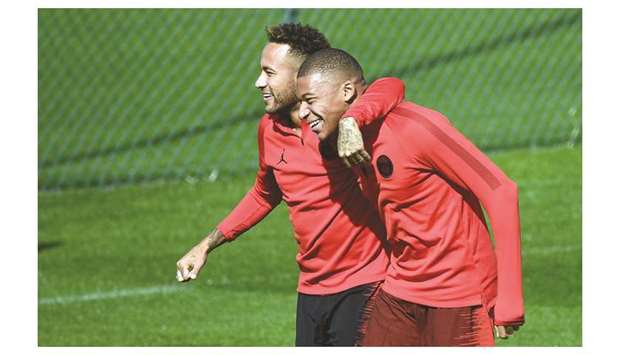 Paris Saint-Germainu2019s Neymar (left) jokes with Kylian Mbappe during a training  session in Saint-Germain-en-Laye, near Paris, on the eve of their UEFA Champions League match against Liverpool. (AFP)