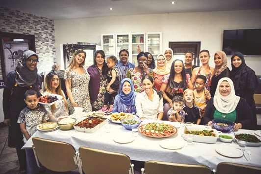Meghan, Duchess of Sussex, poses with women in the Hubb Community Kitchen at the Al Manaar Muslim Cultural Heritage Centre in west London.