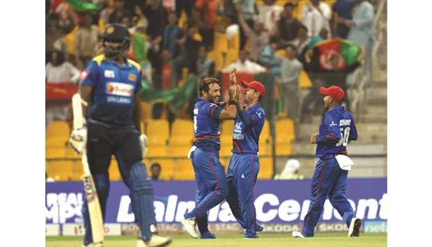 Afghanistanu2019s Gulbadin Naib (second from left) celebrates the wicket of Sri Lankau2019s Thisara Perera (left) with his teammates during the Asia Cup match in Abu Dhabi yesterday. (AFP)
