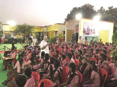 Prime Minister Narendra Modi interacts with school children at a primary school in Narur village in Varanasi yesterday.