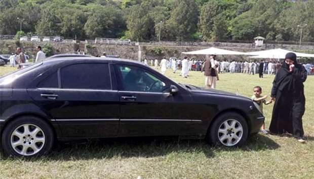 A woman with her child visits an auction of government owned cars at the premises of Prime Minister House in Islamabad on Monday.
