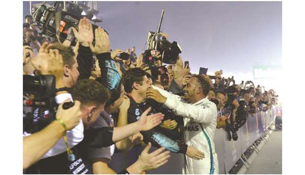 Mercedes driver Lewis Hamilton celebrates with teammates after winning the Singapore Grand Prix on Sunday. (AFP)