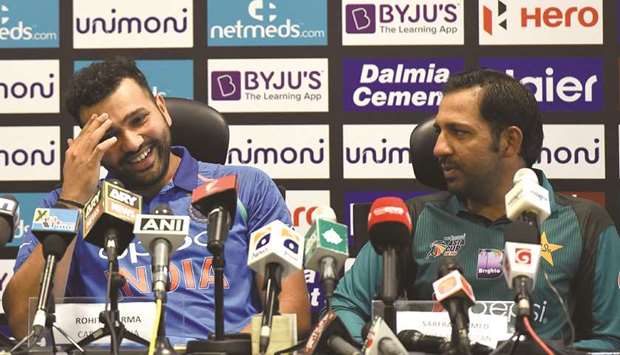 Indian team captain Rohit Sharma (left) talks with Pakistan captain Sarfraz Ahmed during an Asia Cup press conference in Dubai. (AFP)