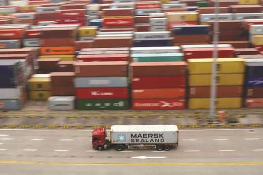 A truck moves past containers at the Yangshan Deep Water Port in Shanghai. China said yesterday that it had no choice but to retaliate against new US trade tariffs, raising the risk that US President Donald Trump could soon impose duties on virtually all of the Chinese goods that America buys.