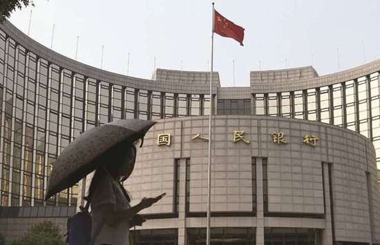 A pedestrian walks past the Peopleu2019s Bank of China headquarters in Beijing. Chinau2019s ever-growing money market funds pose an increasing problem for the nationu2019s central bank as policymakers attempt to boost the flow of credit to cushion an economic slowdown.
