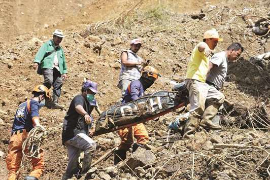 Rescuers carry a body bag containing a landslide victim, after heavy rains during the typhoon, in Itogon, Benguet province.